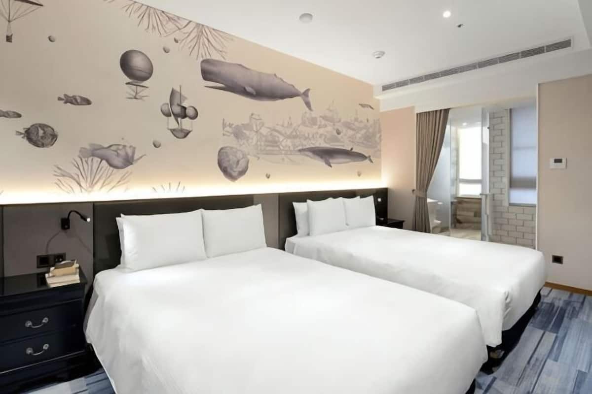 A hotel room with two beds, a nightstand, a wall mural, and a sliding door to a balcony.