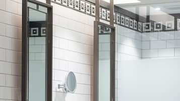 Un baño moderno con un amplio tocador, dos espejos y un salpicadero de azulejos.