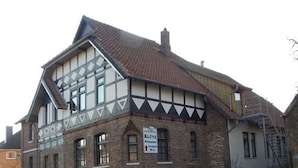 A traditional half-timbered building with a sign indicating a restaurant. - Heide Hotel Klütz (Burgwedel)