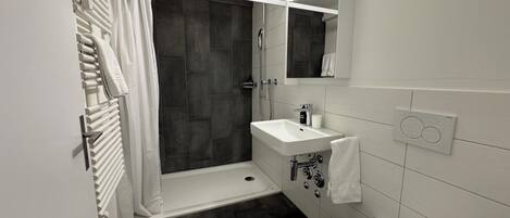 Ein modernes Badezimmer mit Dusche, Waschbecken und Toilette.