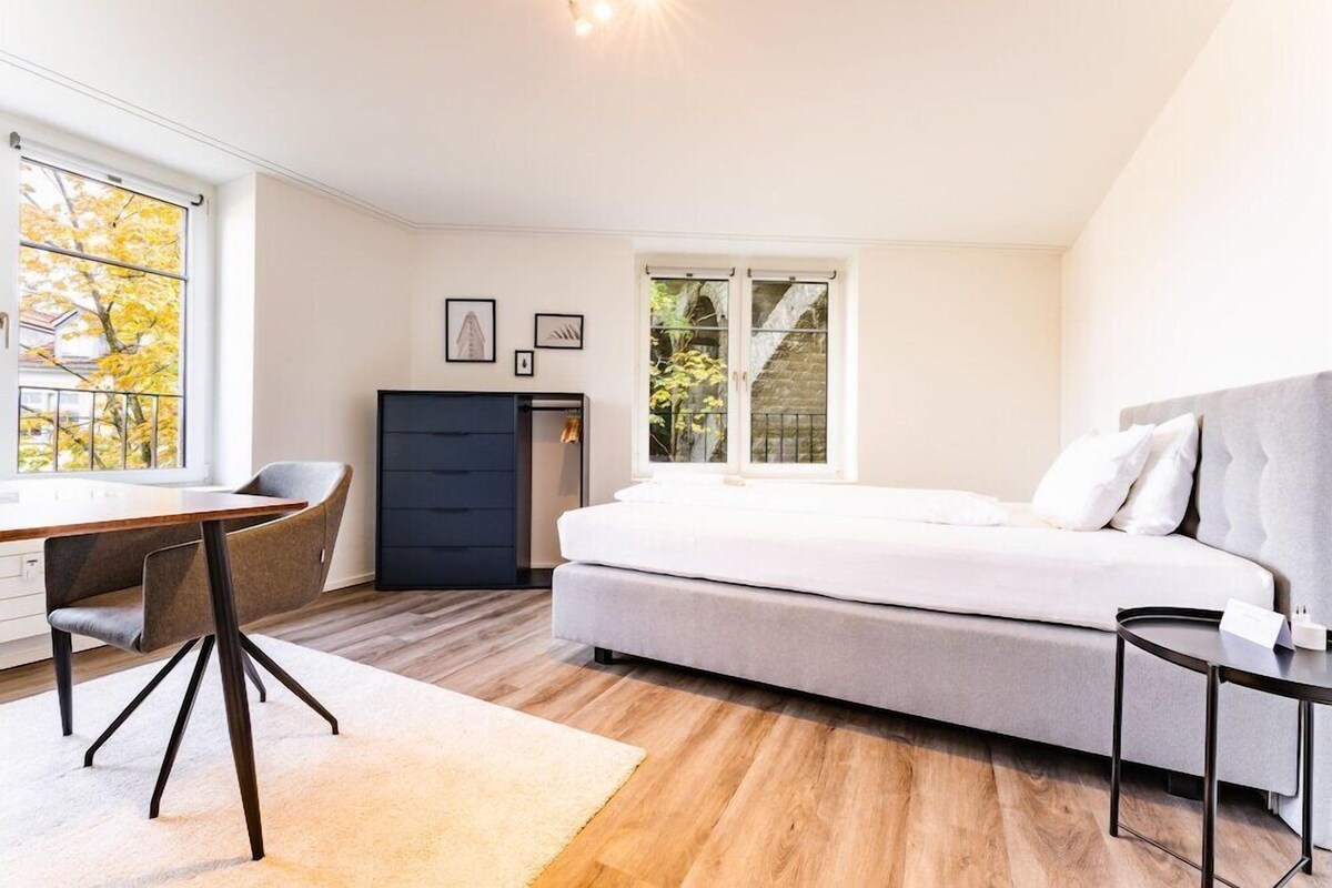 Une chambre à coucher comprenant un lit, un bureau, une chaise et une armoire.