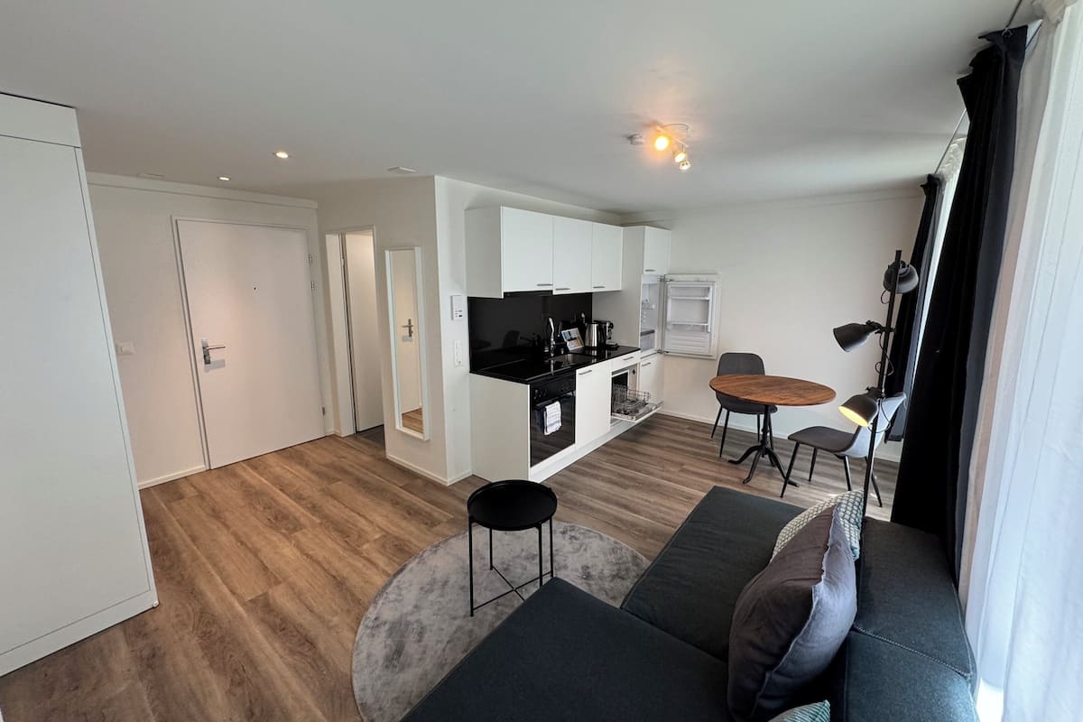 Un apartament modern amb cuina, menjador i saló.