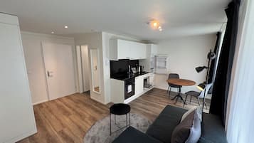 A modern apartment with a kitchen, dining area, and living room.