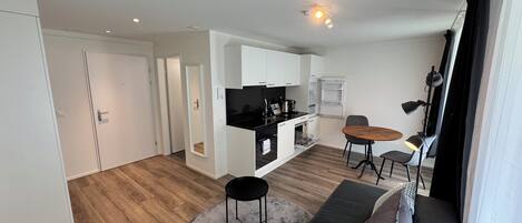 Um apartamento moderno com cozinha, sala de jantar e sala de estar.