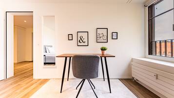 Une chambre moderne avec un plancher en bois, un radiateur blanc, une fenêtre donnant sur un beau paysage et une table avec une chaise.