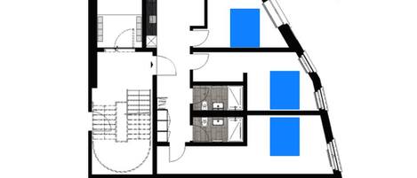 Plano de planta que muestra tres dormitorios, cada uno con cama doble de 180cm x 210cm, una cocina y un baño.
