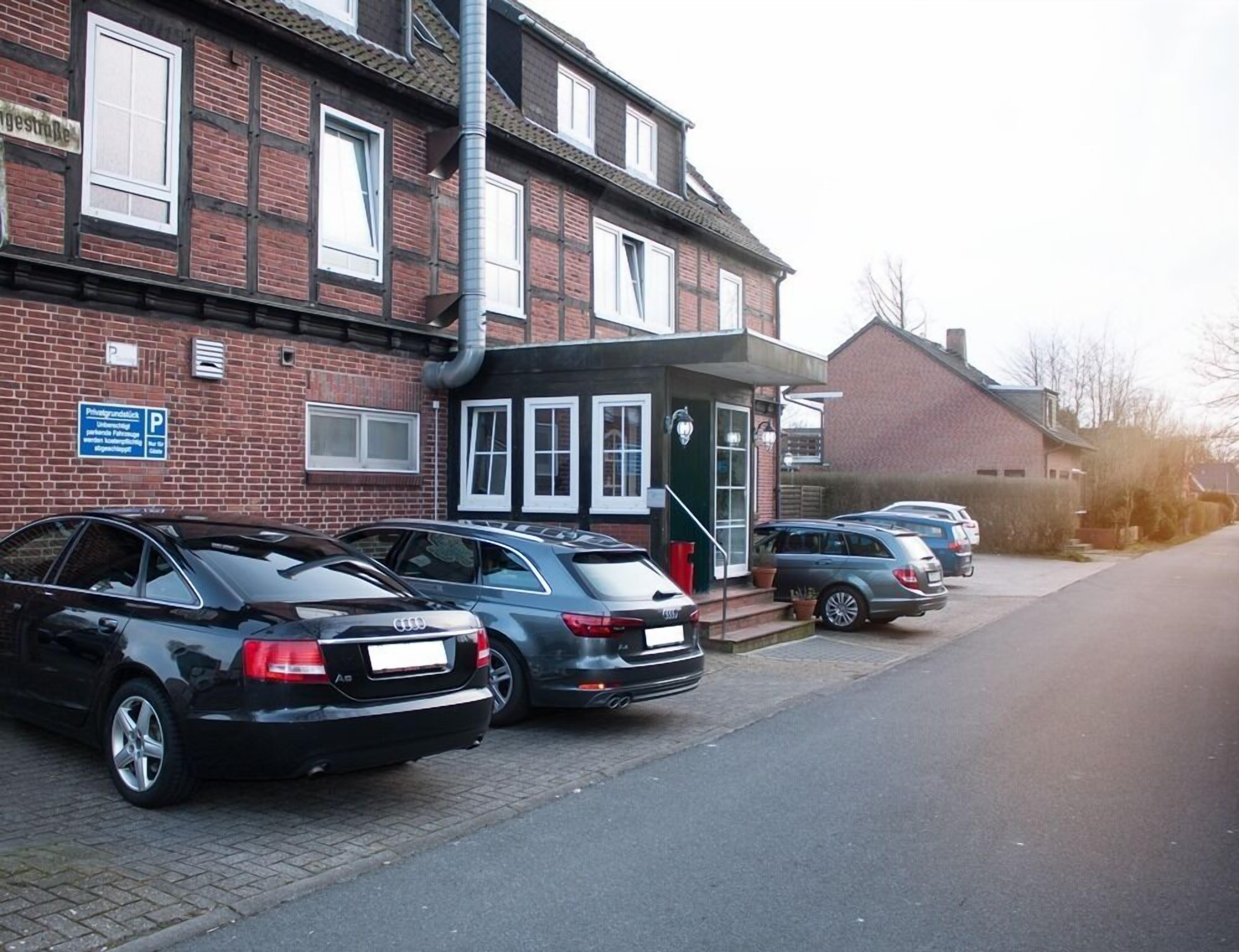 A row of parked cars in front of a building with a sign indicating private parking.