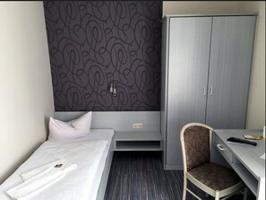 A hotel room with a bed, a desk, a chair, and a wardrobe. - Hotel Landsknecht (Hennef)