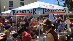 Un espacio al aire libre con mesas y gente.