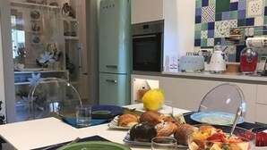 A modern kitchen with a dining area set for a meal. - Al Parco Primavera (Sorrento)