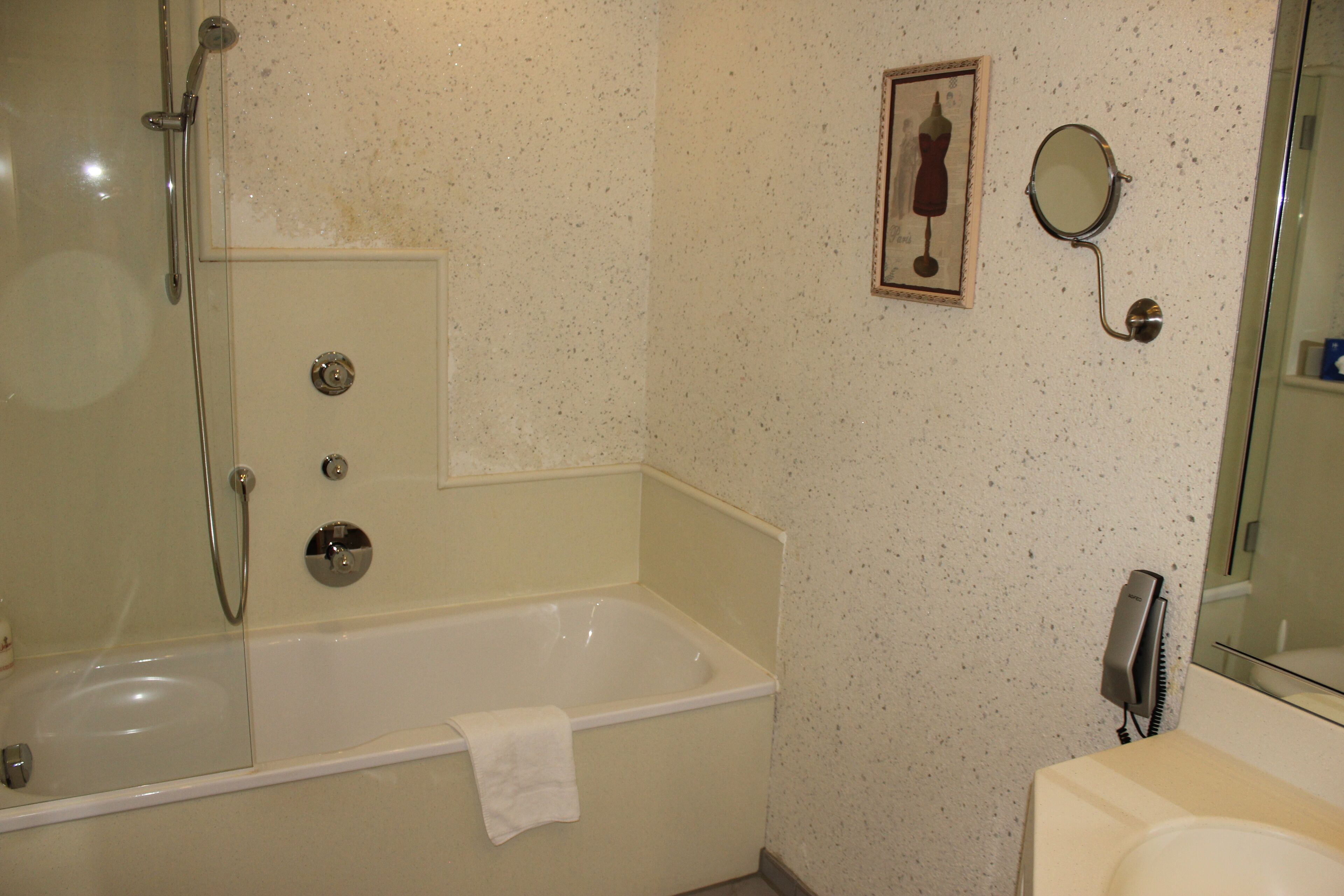 Un baño con bañera, ducha, lavamanos y espejo.