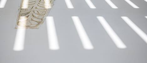 Primer plano de una superficie blanca con textura y listones verticales que proyectan sombras.