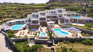 A resort with multiple swimming pools, outdoor seating areas, and a hillside backdrop. - 9 Muses Villas Mykonos (Mykonos)
