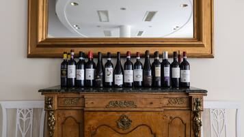 Un armario de madera con un espejo encima, mostrando una fila de botellas de vino.