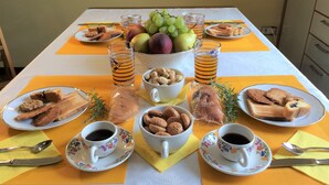 A breakfast table with plates of pastries, fruits, and glasses of juice. - B&B Il Roma (Sulmona)