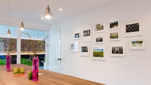 A modern office space with a wooden table, glass partitions, and framed pictures on the wall. - Schlafgut Domhof (Guntersblum)