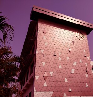 A building with a geometric facade and a logo on the upper right.