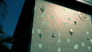 Facciata di un edificio con un motivo geometrico e un logo.