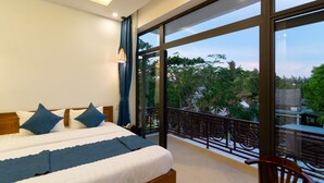 A bedroom with a large bed, a view of the outdoors, and a balcony with a railing. - An Bang Scent Beach Homestay (Da Nang)
