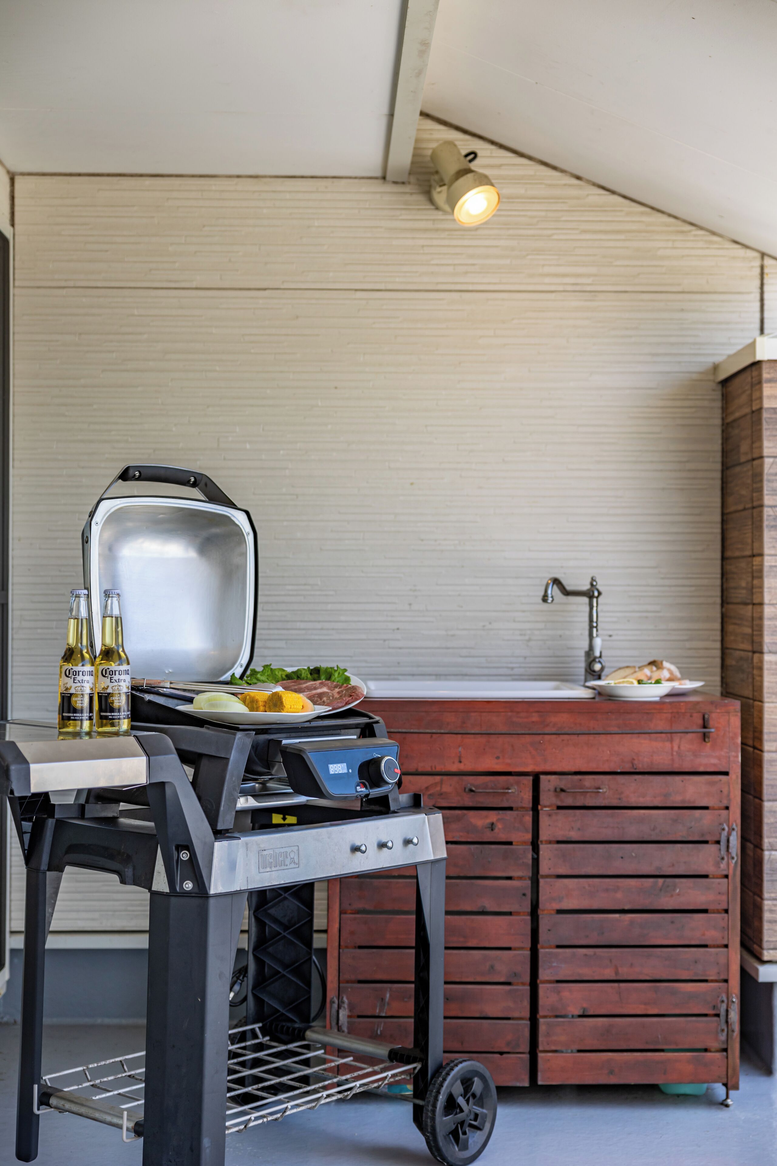 A barbecue setup with a grill, a sink, and a cabinet.