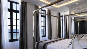 Ein modernes Schlafzimmer mit einem großen Bett, einem Baldachin und Meerblick durch große Fenster.