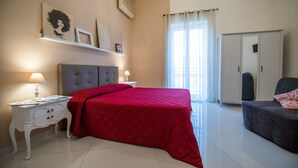A bedroom with a bed, a nightstand, a dresser, a wardrobe, and a window with curtains. - Opus Casa Vacanze (Pompei)