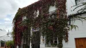 A white building with a sign reading "Tres Soles" and ivy covering the facade. - Hostal Tres Soles (Nerja)