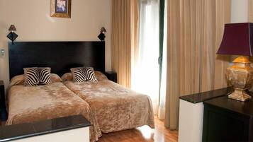 A double bed with zebra-patterned pillows, a dark headboard, and a bedside table with a lamp.