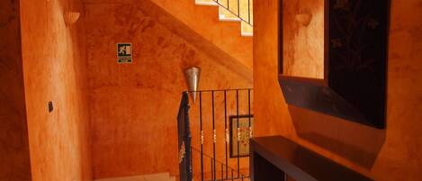 Un intérieur en bois avec un escalier menant à un balcon.