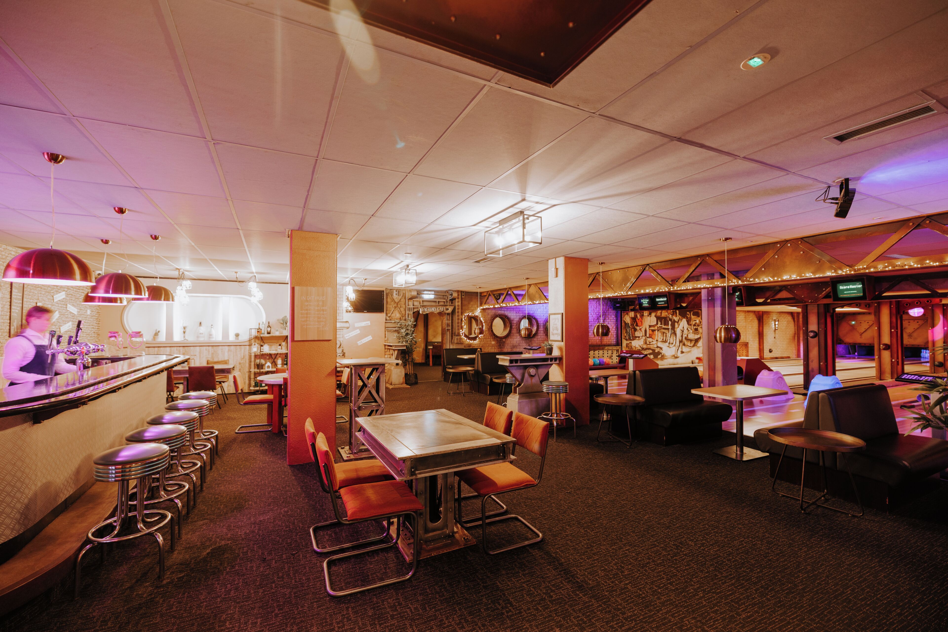 A restaurant interior with a bar area, seating arrangements, and a stage for performances.