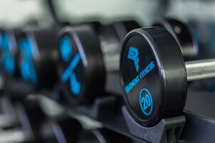 A row of dumbbells with weight markings and symbols indicating different exercises.