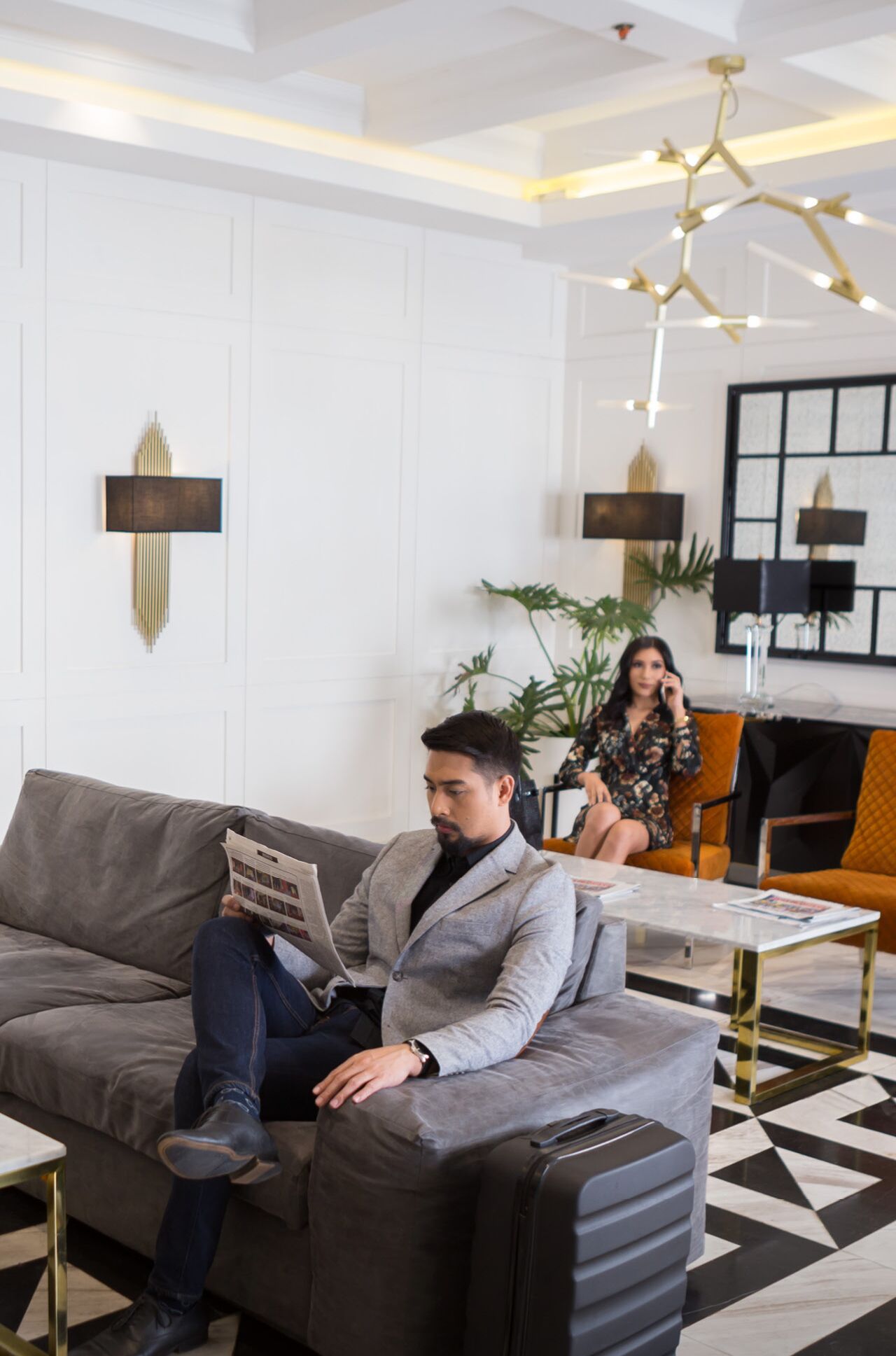 Un salon moderne avec un canapé gris, une table basse et un tapis à motifs.