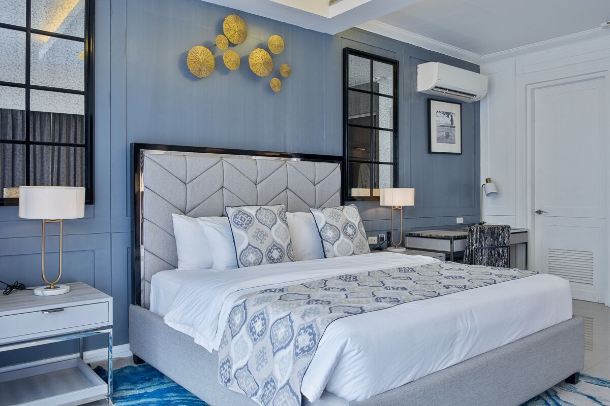 A modern bedroom with a large bed, bedside tables, and decorative wall art.