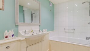 Un baño con lavabo, espejo y bañera.