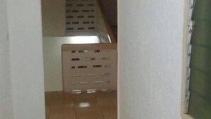 A narrow hallway with tiled flooring leading to a staircase. - New Mexico Hotel - Takoradi (Sekondi-Takoradi)