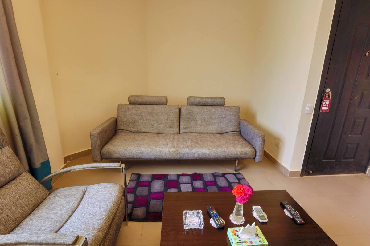Ein Wohnzimmer mit einer Couch, einem Couchtisch und einer Tür.