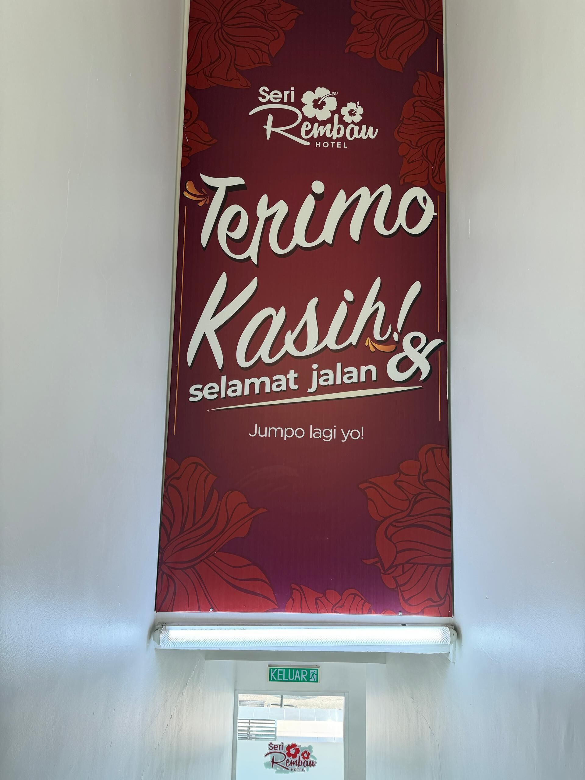 A vertical sign with the text "Seri Rembau Hotel" and "Terimo Kasih selamat jalan" with a floral design.