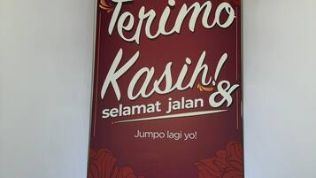 A vertical sign with the text "Seri Rembau Hotel" and "Terimo Kasih selamat jalan" with a floral design.