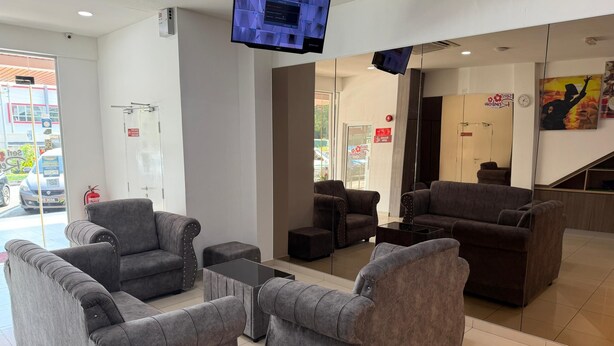 A lobby with grey sofas, a coffee table, and a TV mounted on the wall. - Hotel Seri Rembau (Rembau)