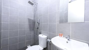 Un bany modern amb rajoles grises, un vàter blanc, una dutxa i un lavabo amb un mirall a dalt.