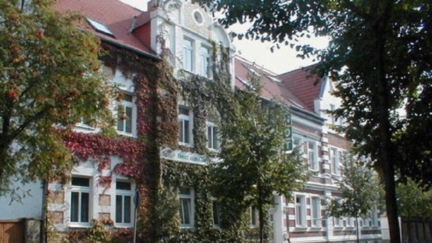Eine Reihe traditioneller europäischer Gebäude mit Stein-Fassaden und roten Ziegeldächern.