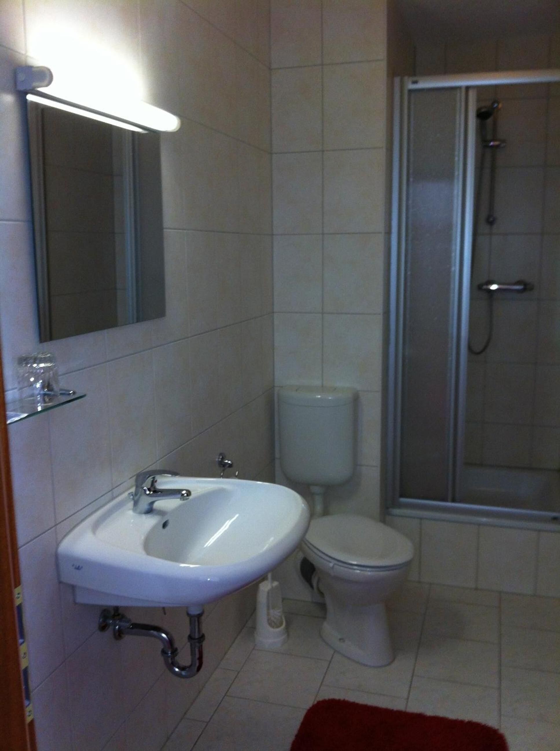 A bathroom with a sink, toilet, and shower.