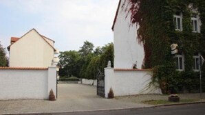 Ein weißes Gebäude mit rotem Ziegeldach und einem ehrfurchtgebietenden Eingangstor.