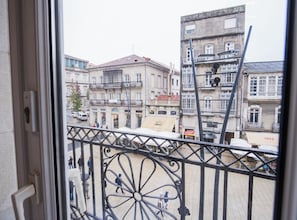 A balcony with wrought iron railings overlooking a city street.