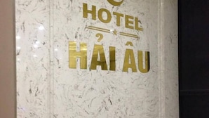 A marble wall with the text "HOTEL HAI AU" and a stylized logo above it. - Hotel Hai Au (Hanoi)
