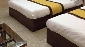 A hotel room with two beds, a wooden headboard, a marble floor, and a wooden table. - Hotel Hai Au (Hanoi)