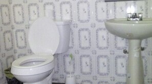 A bathroom with a toilet and sink. - Amaja Lodge (Sekondi-Takoradi)