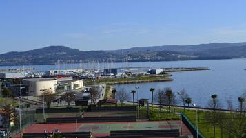 A basketball court with a view of a lake and distant hills.