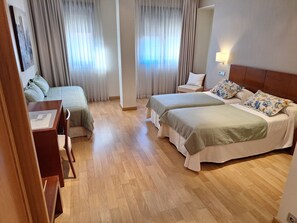 A hotel room with two beds, a desk, and a chair. - Hotel Astura (Valencia de Don Juan)