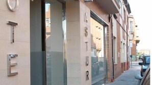 Un hotel con fachada moderna, amplios ventanales de vidrio y entrada visible.